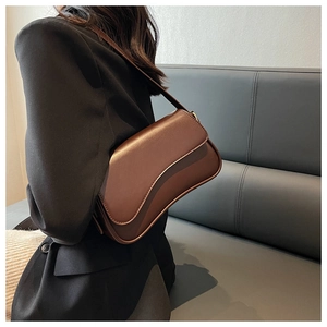 Chic brown PU leather underarm bag with glossy finish shown on model's shoulder