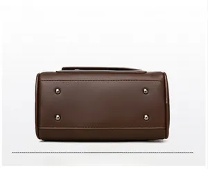 Detail of bag bottom with four metal protective studs and neat stitching on brown leather