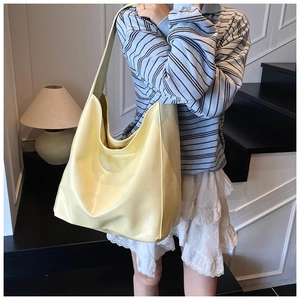 Detail of light yellow hobo bag in soft leather texture for daily commuting use