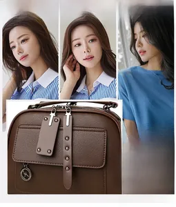 Close-up of dark brown lychee leather handbag featuring a metal zipper and kangaroo charm