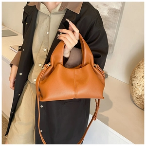 Caramel leather cloud bag detail showing soft pleated texture and gold hardware finish