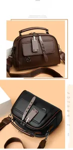 Detail of dual-color leather handbags with kangaroo charm and wide fabric strap