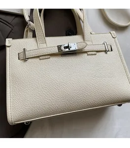 Détail du sac à main blanc cassé en cuir grainé avec fermoir rotatif en métal argenté
