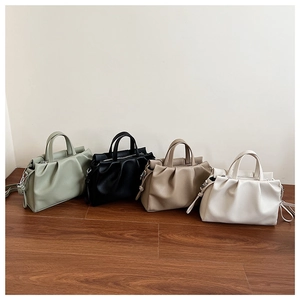 Detail showing pleated bucket bags in four colors with adjustable shoulder straps
