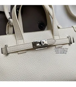 Détail du fermoir en argent et cuir grainé sur un sac à main beige élégant