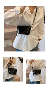 Détails du sac seau en cuir verni noir avec pendentif sphérique argenté et fini poli