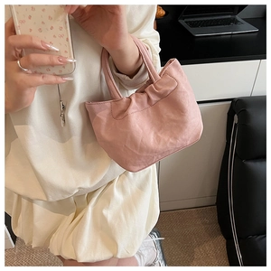 Close-up of pink pleated cloud bag with soft leather texture and stylish top handle