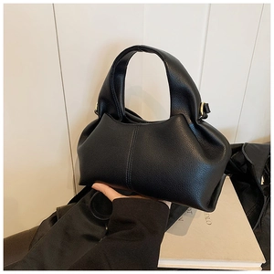 Détail de la texture en cuir grainé noir et design plissé élégant sur le sac à main