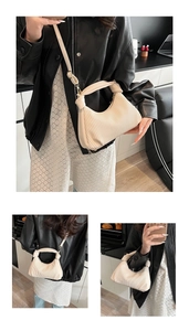 Detail of off-white pleated crescent bag showing accordion texture and knot handle