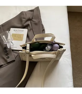 Intérieur spacieux du sac blanc cassé grainé contenant des cosmétiques et essentiels