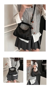 Close-up of black pleated crossbody bag with fine vertical textures and adjustable strap