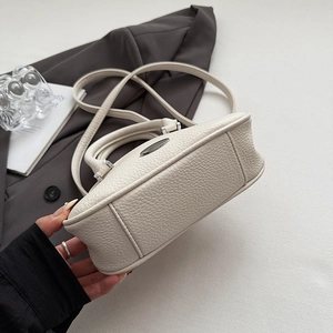 Dettaglio della borsa in pelle martellata bianco sporco con texture morbida e base