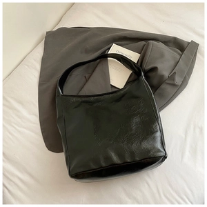 Detailed close-up of textured black oil wax leather and wide strap on large tote bag