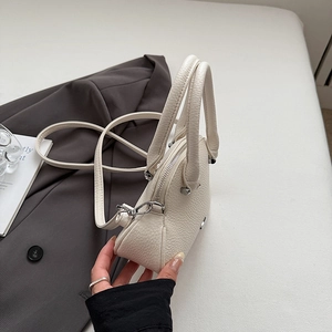 Dettaglio della pelle a grana bianca su una borsa a mano con finiture argentate