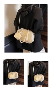 Detalle de bolso bowling en cuero crema con correa y monedero pequeño desmontable