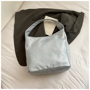 Detail of light blue-grey soft faux leather hobo shoulder bag with wide strap design