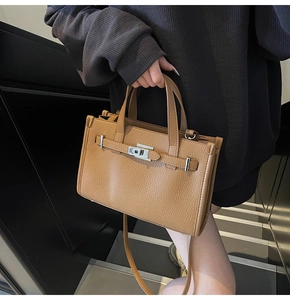 Détail du sac à main en cuir marron avec texture litchi et boucle en argent poli
