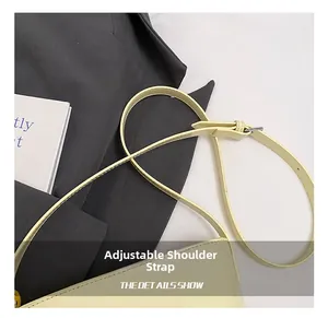 Vue macro de la bandoulière réglable en cuir crème avec boucle argentée et couture