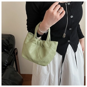 Close-up of pleated mint green cloud tote bag in soft leather with dual handles