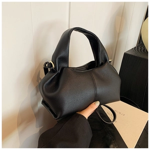 Détail du sac à main noir en cuir litchi avec plis élégants et boucles dorées chic