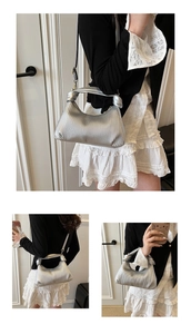 Detail of silver pleated crescent pea bag featuring knot handle and adjustable strap