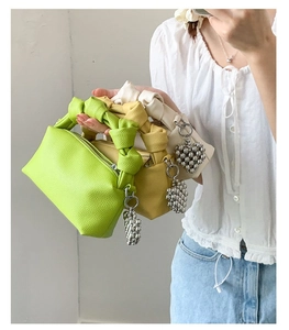Mini handbag with knot handle in lime green, yellow, and white featuring heart charms