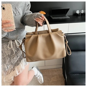 Detailaufnahme der beigen Rafftasche aus weichem Leder mit Narbenstruktur und Knotendetail