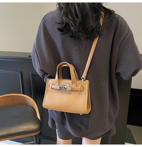 Vue arrière d'un mannequin portant un sac à main marron à motif litchi de style Kelly