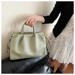 Detailed view of the sage green pleated tote bag with荔枝textured leather and drawstring