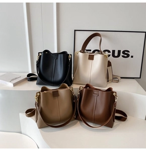 Modern bucket bags in four colors with wide fabric straps and metallic hardware details