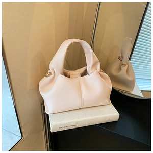 Détail d'un sac nuage plissé beige montrant l'anneau en D latéral et le cuir mat de qualité
