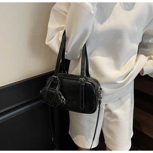 Detalle del bolso bowling negro con mini estuche extraíble y herrajes metálicos plateados
