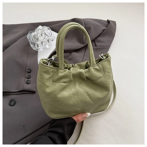 Close-up of ruched avocado green cloud bag featuring pleated faux leather and top handle