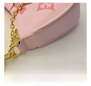 Detail of pink lychee leather bag with floral embossing and gold chain strap