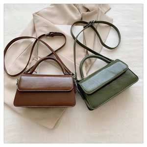 Close-up of vintage faux leather mini crossbody bags in dark brown and olive green colors