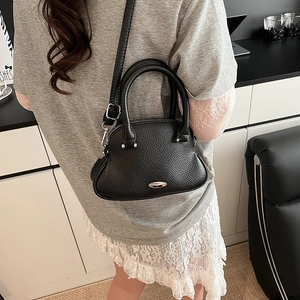 Vista laterale di una borsa a tracolla in pelle nera su una modella per lo stile quotidiano
