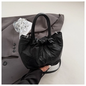 Detail of black pleated cloud bag with soft leather texture and silver hardware accents