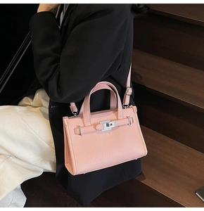 Mini sac rose en cuir grainé avec fermoir rotatif métallique et bandoulière amovible