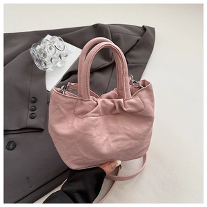 Detailed close-up of soft pleated pink cloud bag with silver hardware and slim strap
