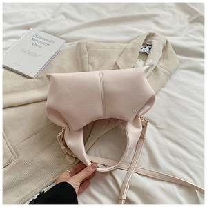 Detail shot of pink dumpling bag with lychee texture leather and adjustable strap