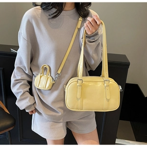 Elegante conjunto de bolso bowling amarillo y mini neceser colgado como bandolera