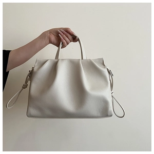 Detail of off-white ruched tote bag showing lychee grain leather texture and drawstring