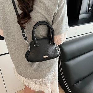 Dettaglio mini borsa in pelle martellata nera con zip argentata e tracolla regolabile
