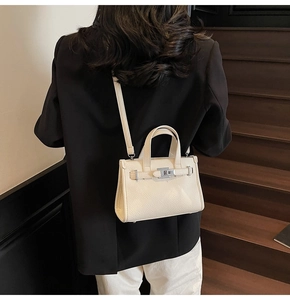 Gros plan du mini sac à main en cuir grainé blanc avec fermoir argenté et bandoulière
