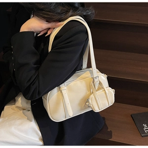 Detalle de un bolso Boston beige con monedero mini en una modelo elegante