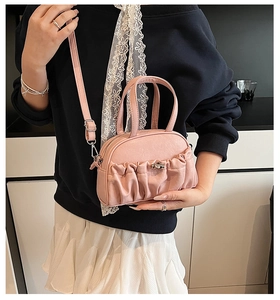 Detail of pink pleated shell bag with premium PU texture and metal clasp closure