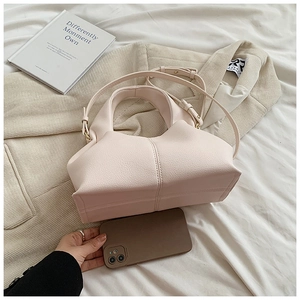 Detailed size comparison of a light pink lychee grain leather handbag with a smartphone