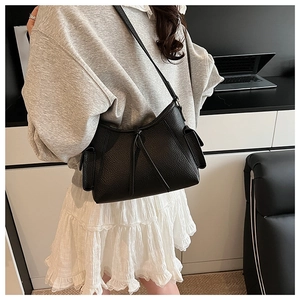 Detailansicht der schwarzen Hobo-Tasche aus genarbtem Leder mit schmalem Riemen und Fach