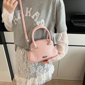 Dettaglio della borsa rosa in pelle martellata con design curvo e logo argento