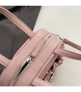 Detailed close-up of the smooth silver zipper and pink pleated texture on this stylish handbag